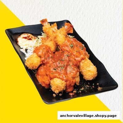 A black plate holds crispy fried shrimp and cutlets generously covered in a rich red sauce, served with coleslaw.