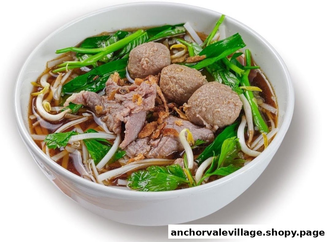 A close-up of a delicious bowl of Thai beef noodle soup with meatballs and fresh vegetables.