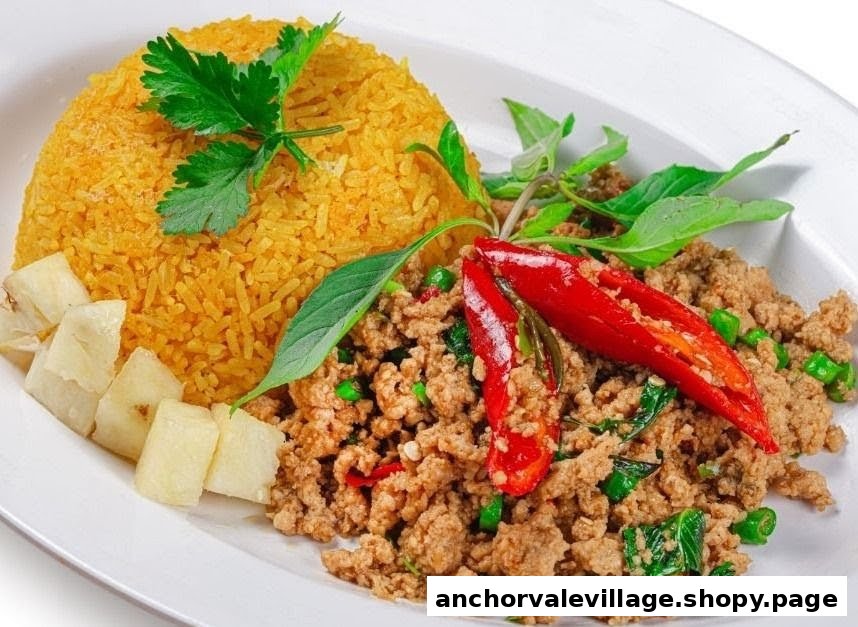 A vibrant plate of Thai basil stir-fry with minced meat, red chilies, and golden rice.