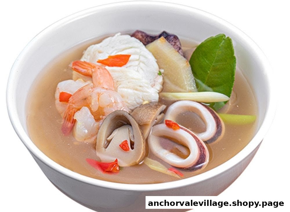 A vibrant bowl of Thai seafood soup featuring shrimp, squid, fish, and mushrooms.