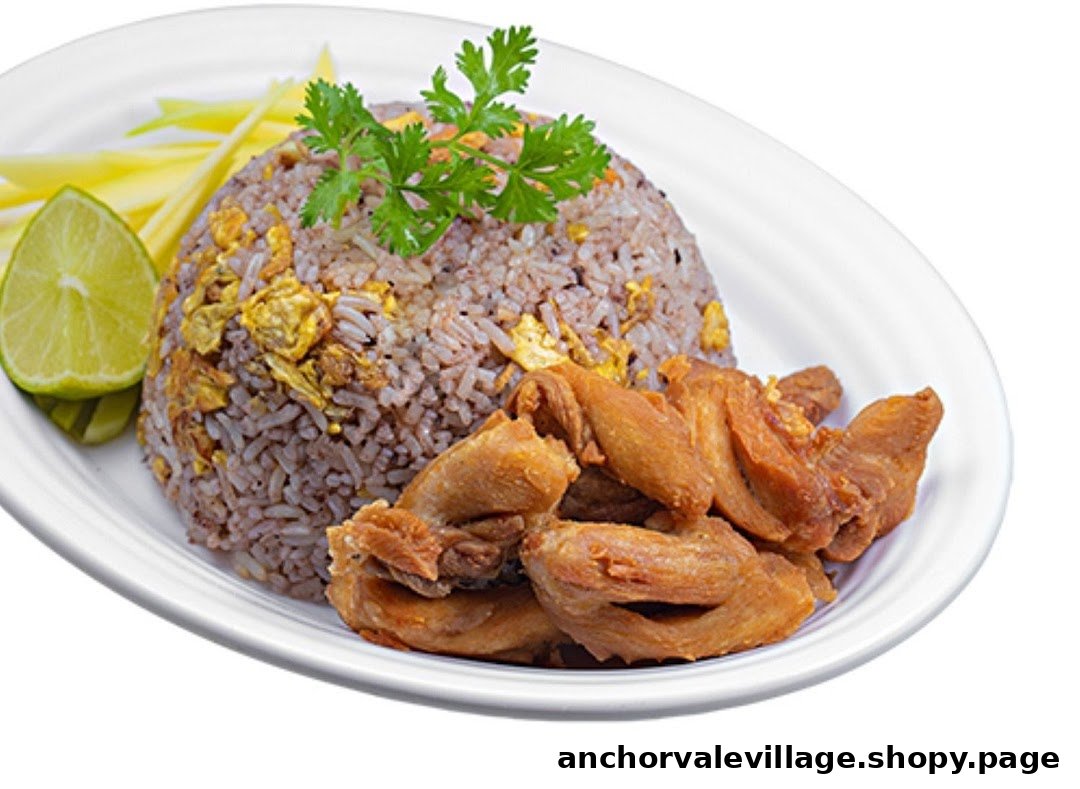 A vibrant plate featuring Thai fried rice, crispy fried chicken, fresh lime, and sliced mango.