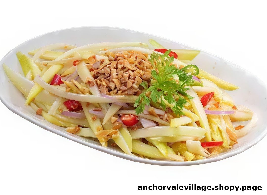 A vibrant Thai mango salad with peanuts, red onions, and chili, garnished with fresh cilantro.