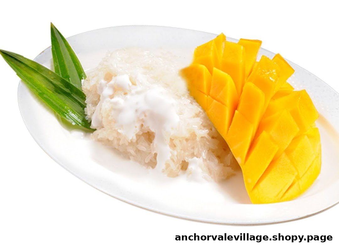 A plate of traditional Thai mango sticky rice with coconut milk and pandan leaves.