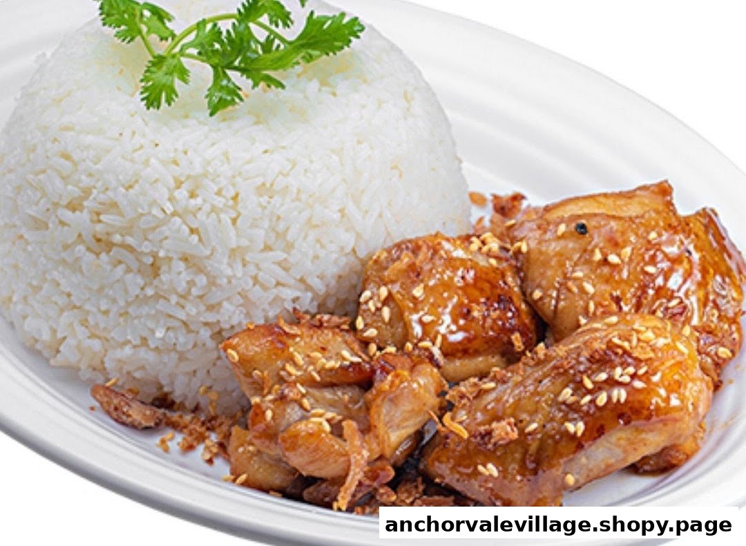 Delicious glazed chicken with sesame seeds and fried garlic, served alongside fluffy white rice.