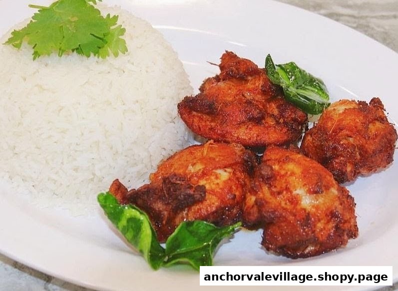 A plate of golden fried chicken pieces served with fluffy white rice and fresh herbs.