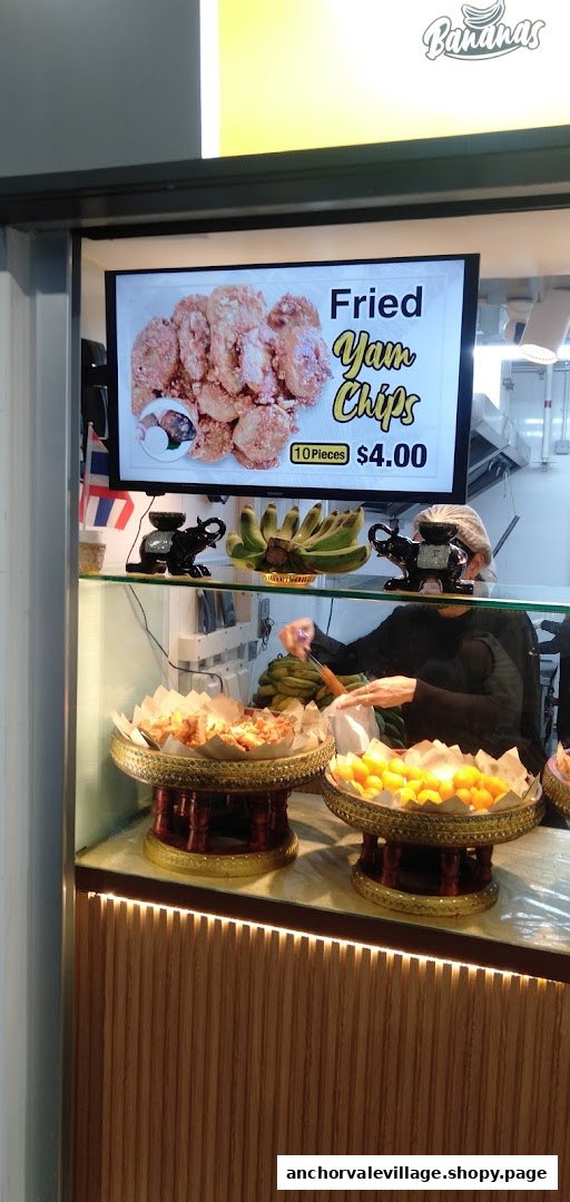 Interior view of Thai Khanom Bananas showcasing traditional fried snacks and a staff member.