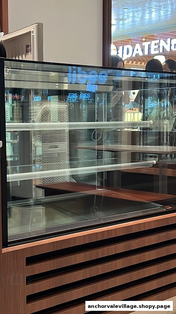 An empty glass display case with wooden base, ready for delicious treats.