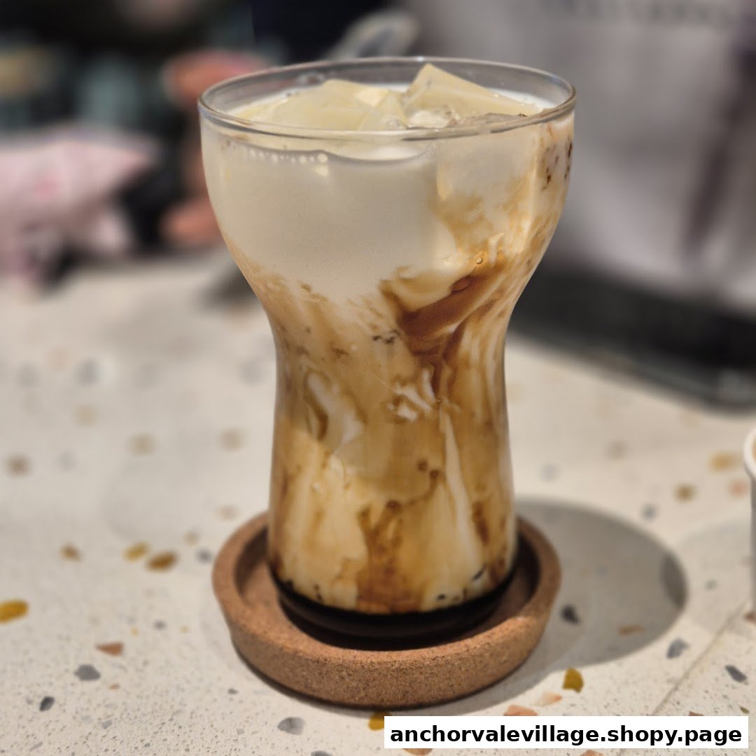 A refreshing iced drink with caramel swirls and ice cubes on a cork coaster.