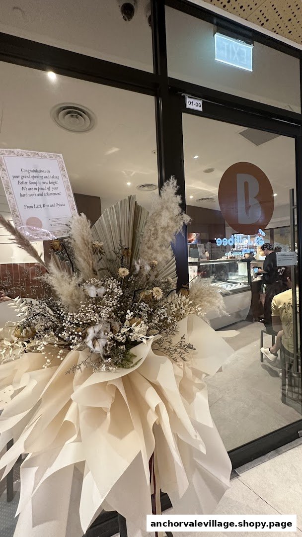 The Better Scoop shop entrance adorned with a large congratulatory floral arrangement.