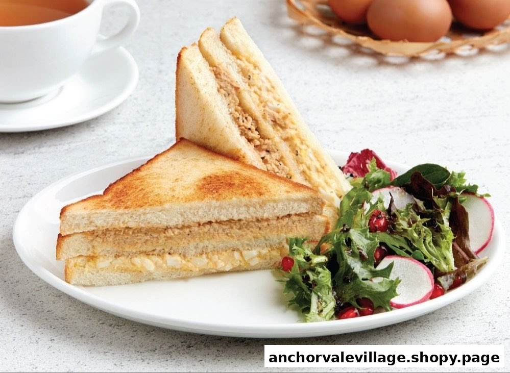 A plate featuring two toasted sandwiches, a fresh side salad, and a cup of tea in the background.