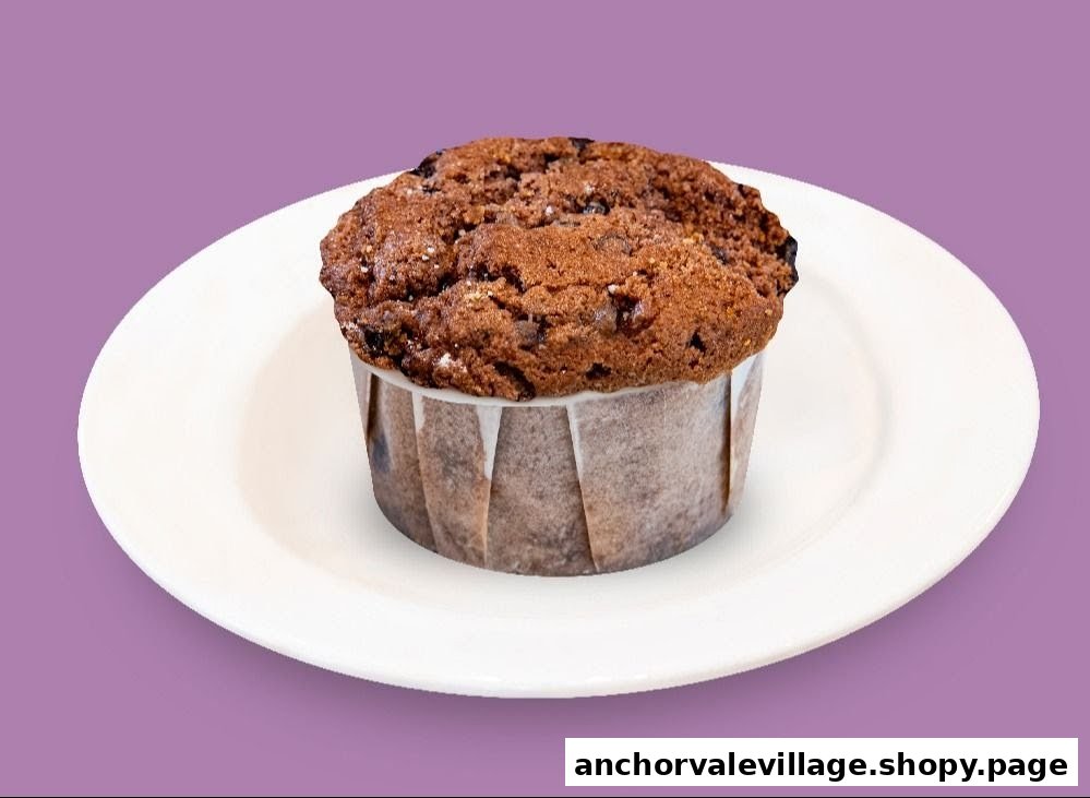 A delicious chocolate muffin on a white plate against a purple background.