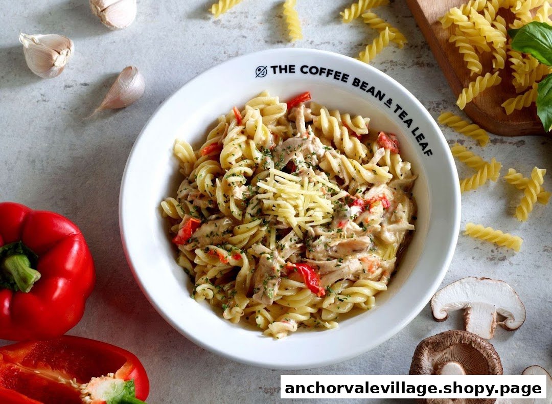 A delicious bowl of fusilli pasta with chicken, bell peppers, and cheese, surrounded by fresh ingredients.