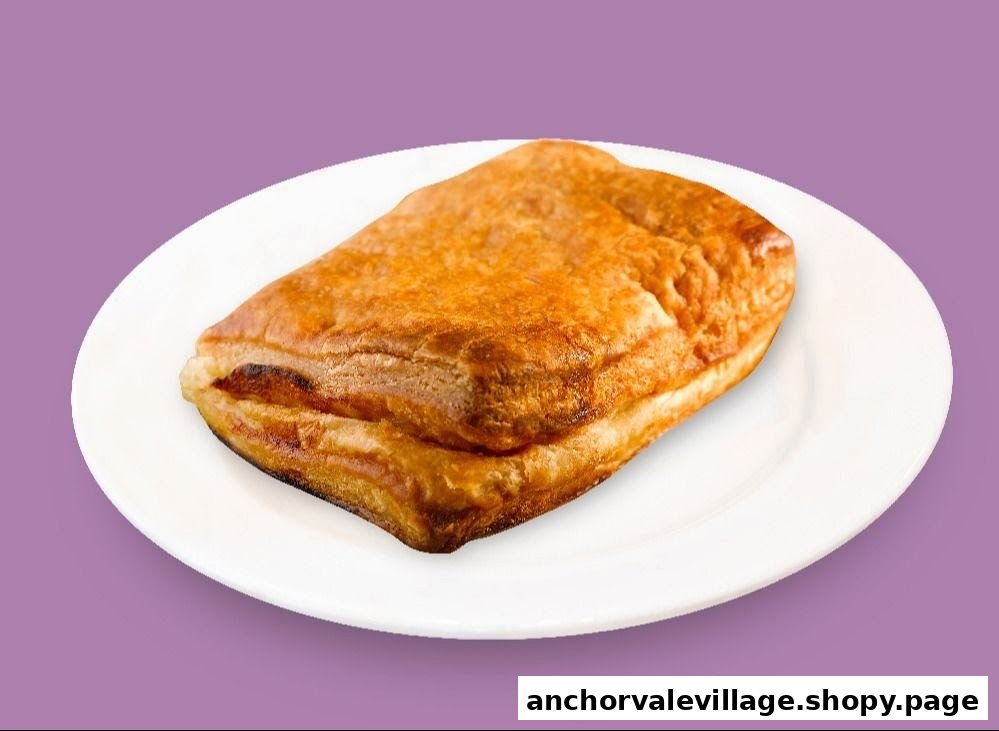 A golden-brown, flaky pastry on a white plate against a purple background.