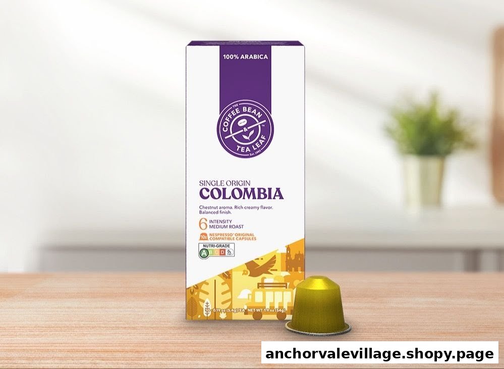 A box of The Coffee Bean & Tea Leaf Single Origin Colombia coffee capsules with one capsule on a wooden surface.
