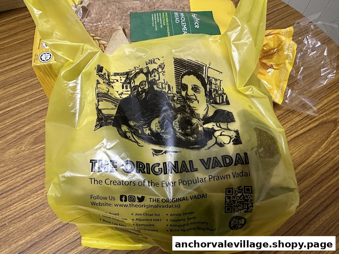 A yellow plastic bag from The Original Vadai, featuring its branding and slogan.