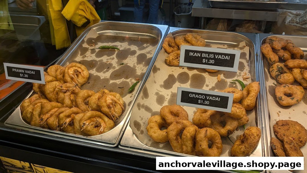 A display of freshly fried vadai varieties, including Prawn, Ikan Bilis, and Grago, with price tags.