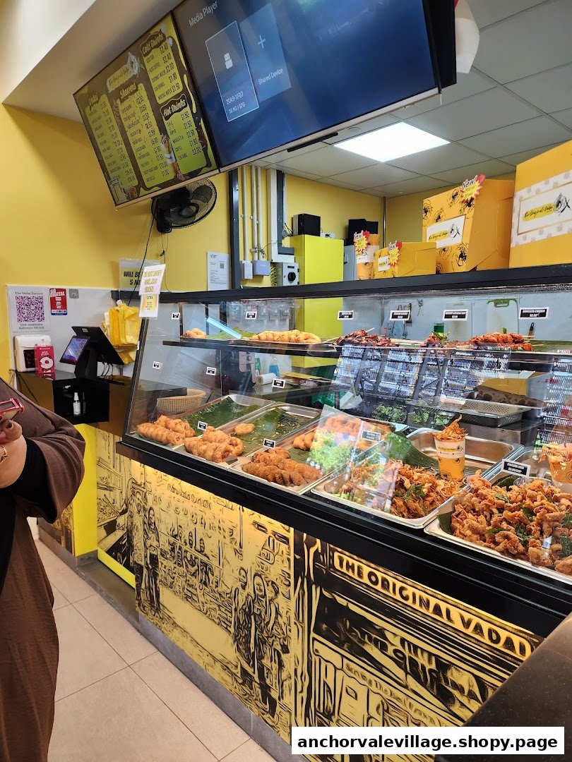 Interior view of The Original Vadai, showcasing a vibrant food display counter and menu board.