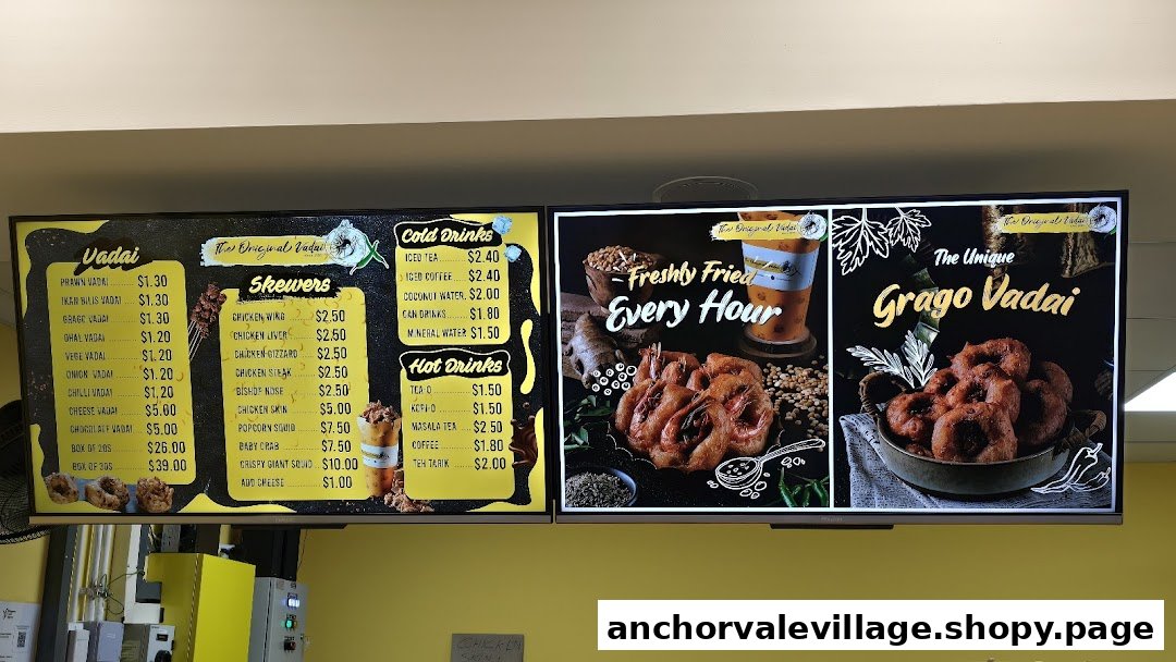 A digital menu board displaying vadai, skewers, and various hot and cold drinks with prices.