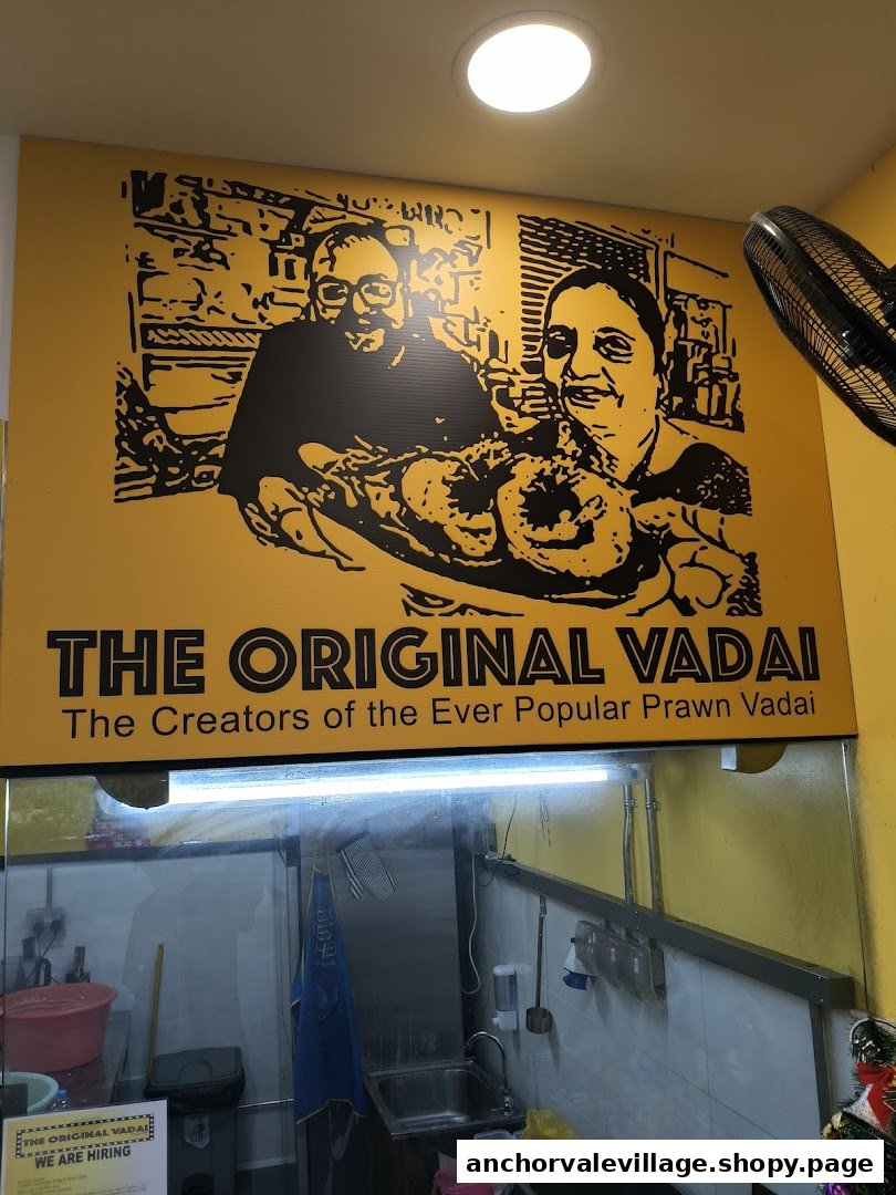 An interior shot of The Original Vadai featuring a large yellow sign with black illustrations and text.