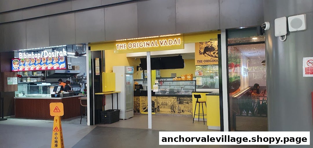 The bright yellow shopfront of The Original Vadai, showcasing its entrance and counter area.