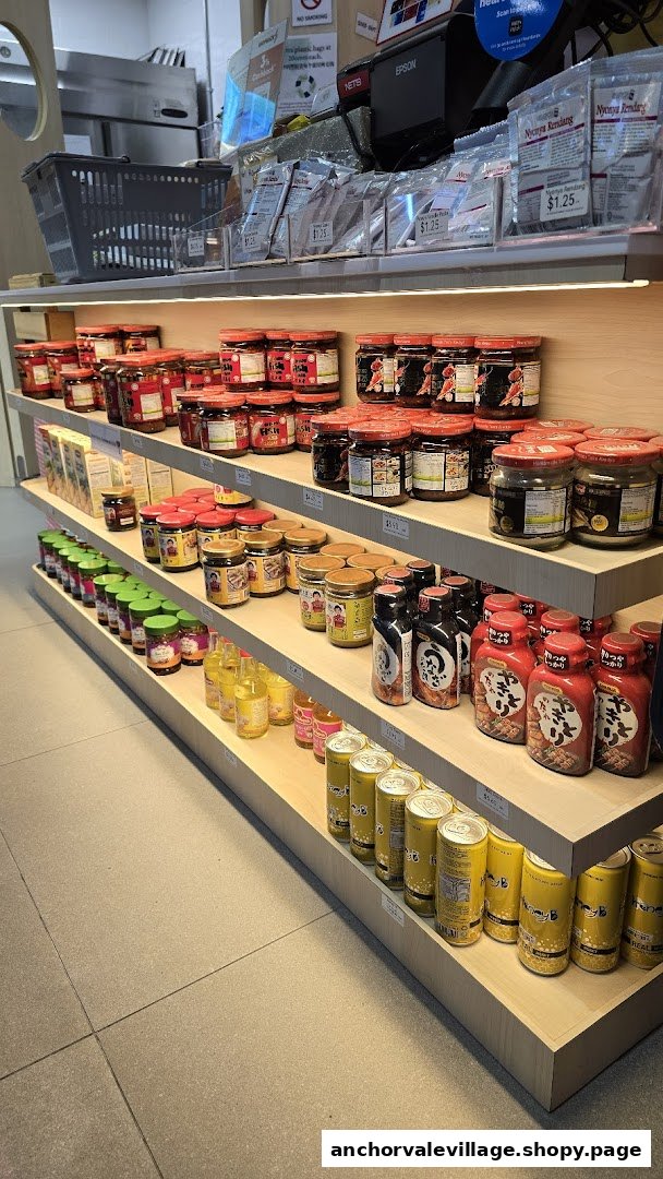 Shelves stocked with a variety of sauces, condiments, and beverages in a retail food shop.