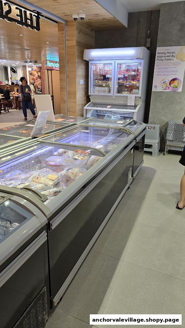 Rows of freezers displaying various frozen seafood products inside The Seafood Market Place.