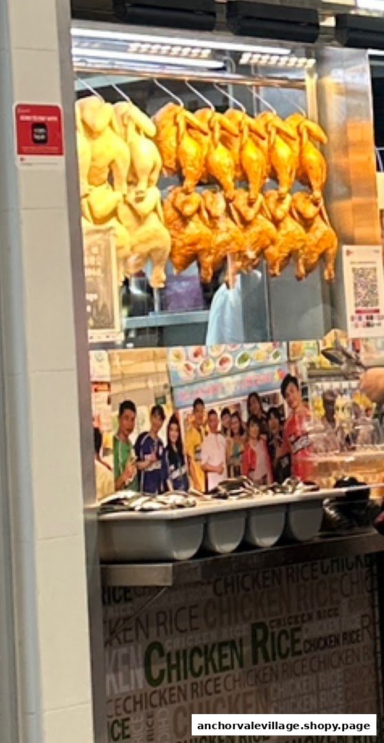 A food stall display featuring rows of hanging roasted and poached chickens, with a counter below.