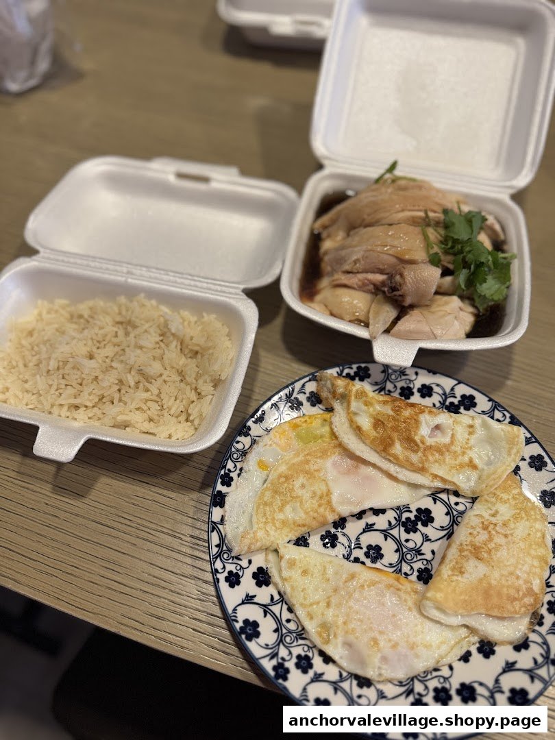 A delicious takeout meal featuring Hainanese chicken, fragrant rice, and fried eggs.