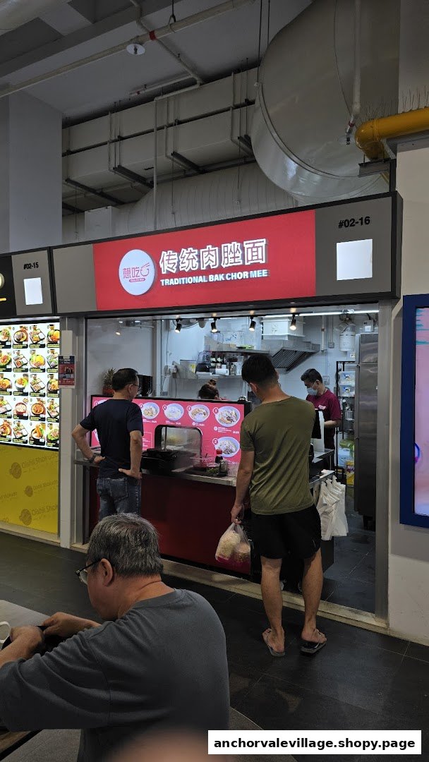 Customers queueing at a traditional Bak Chor Mee stall in a bustling food court.