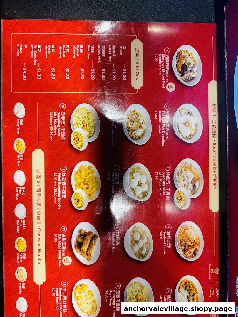A vibrant red menu board displaying various noodle dishes, soups, and add-ons with prices and images.