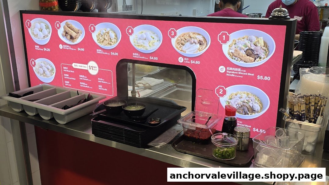 A digital menu board displaying various noodle and soup dishes with prices at a food stall.