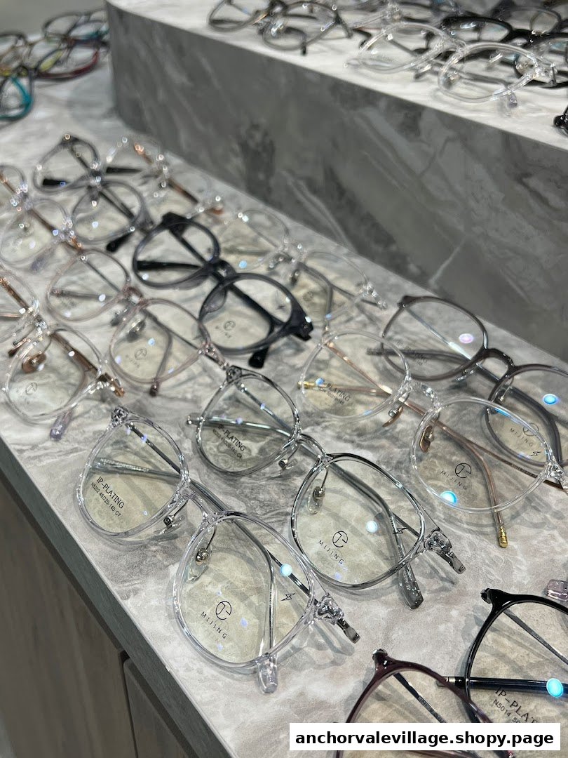 A close-up view of various stylish eyeglasses displayed on a marble-patterned counter.