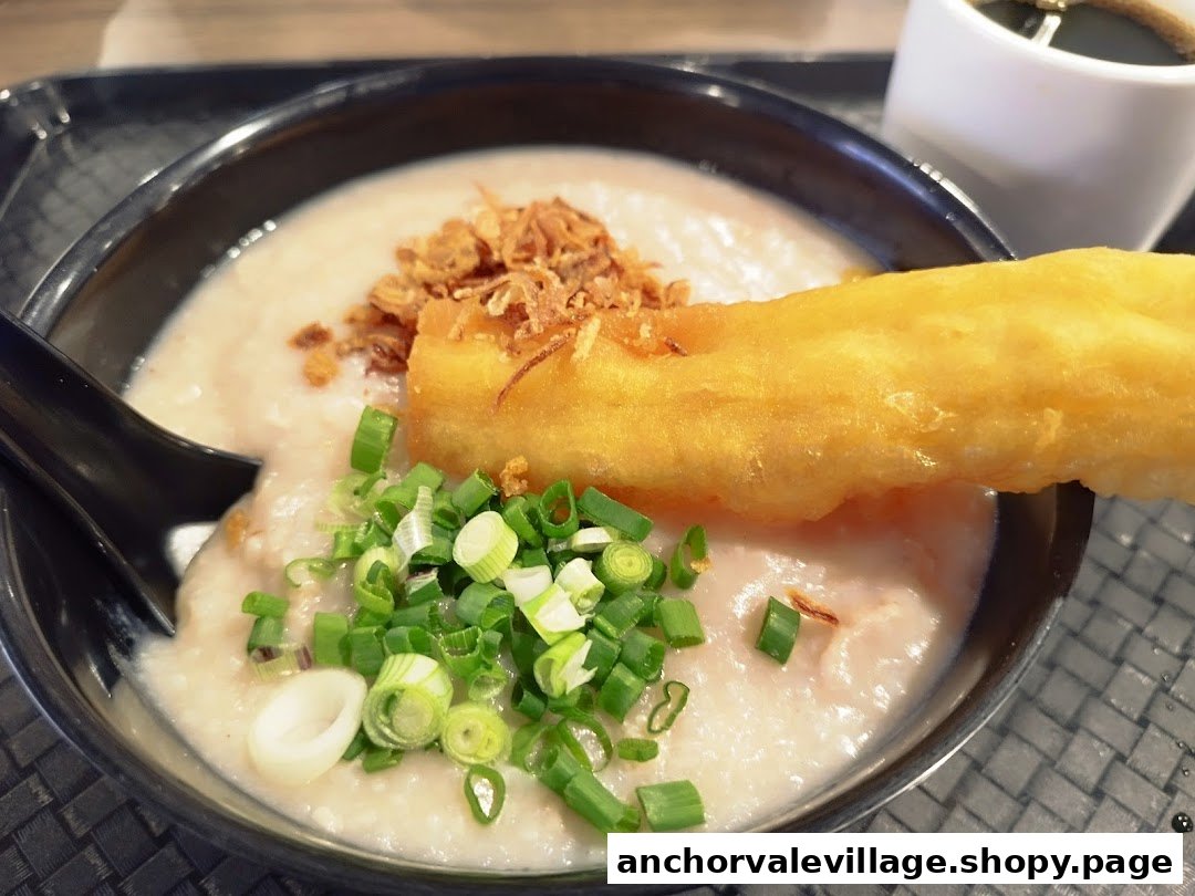 A close-up of a bowl of congee topped with fried dough, scallions, and crispy shallots.