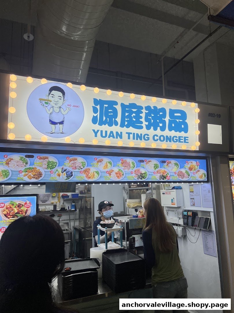The illuminated storefront of Yuan Ting Congee, showing customers at the counter.