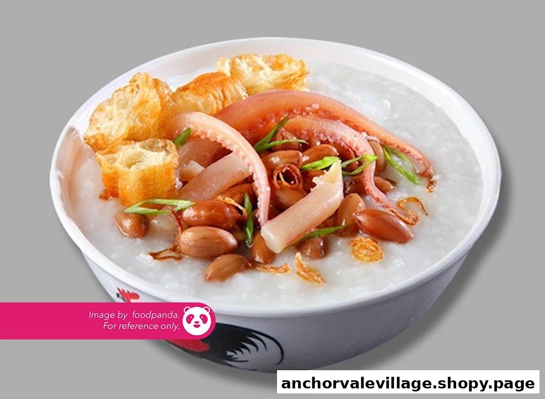 A close-up of a bowl of congee topped with squid, peanuts, fried dough, and scallions.