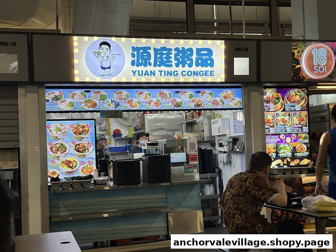 The illuminated storefront of Yuan Ting Congee, a bustling food stall, showcasing its name and digital menu displays.