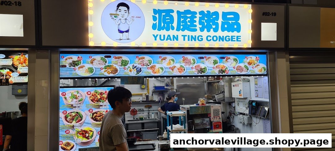 Front view of Yuan Ting Congee stall with illuminated signage, digital menu displays, and staff inside.