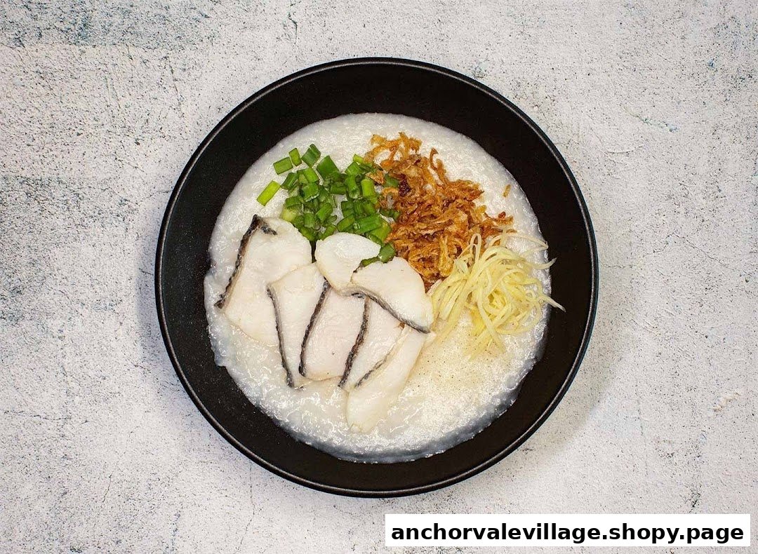 A bowl of fish congee topped with scallions, fried shallots, and shredded ginger.