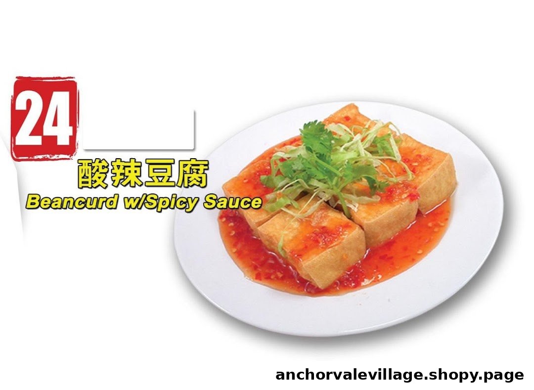 A plate of golden fried beancurd topped with spicy sauce, cilantro, and shredded greens.
