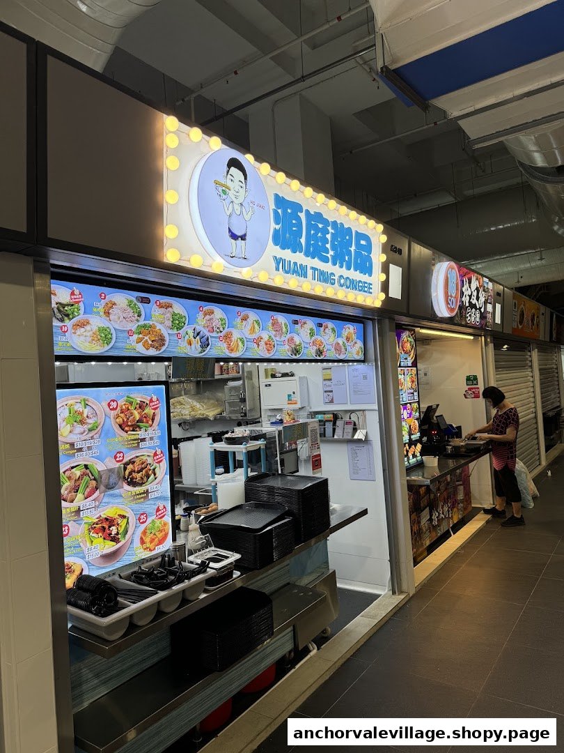 The brightly lit front of Yuan Ting Congee food stall, showcasing its menu displays and a customer.