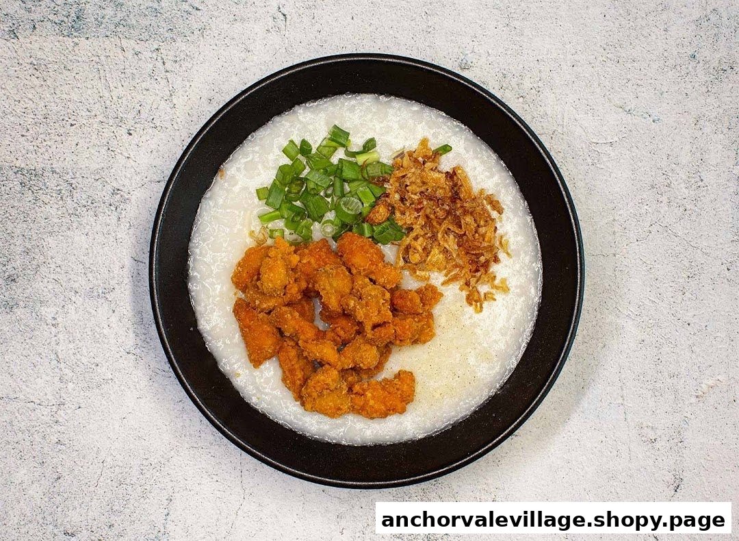 A bowl of congee topped with crispy fried chicken, green onions, and fried shallots.