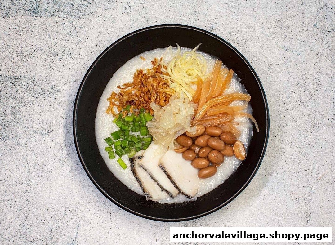 A close-up of a bowl of congee topped with various ingredients like peanuts, fried shallots, and scallions.