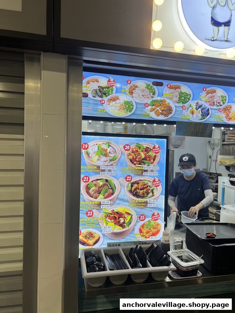 A food stall counter displaying a comprehensive menu of congee and claypot dishes, with a staff member preparing food.