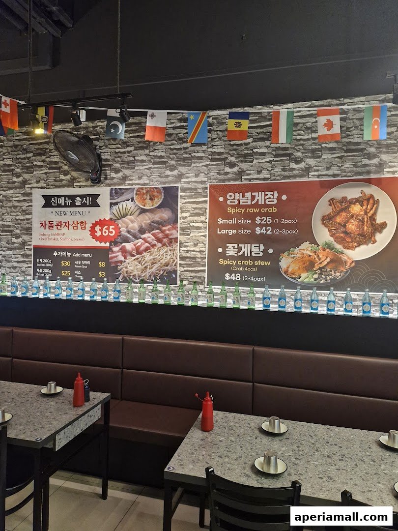 Interior of a restaurant with a menu board displaying seafood and meat dishes, and bottles of drinks.