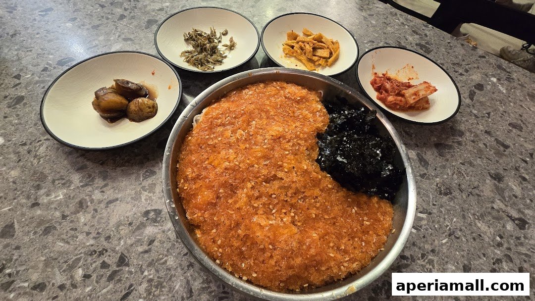 A delicious Korean meal featuring a large portion of seasoned rice with side dishes of kimchi and dried anchovies.