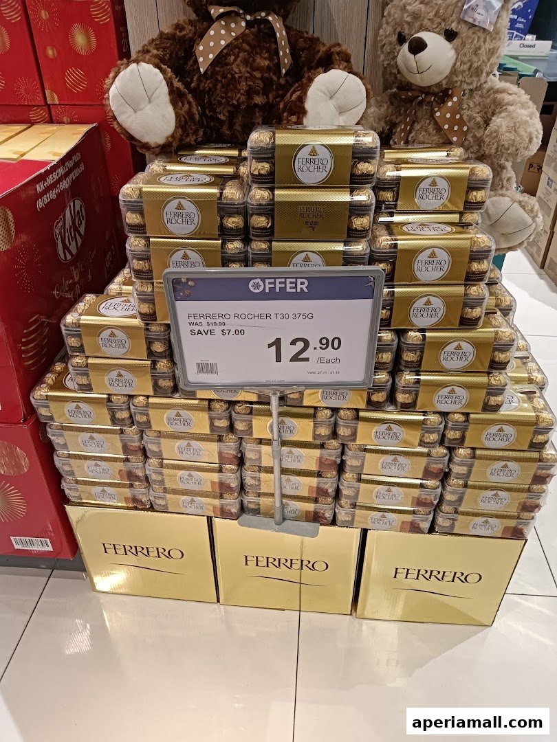 A display of Ferrero Rocher chocolates with teddy bears in the background.