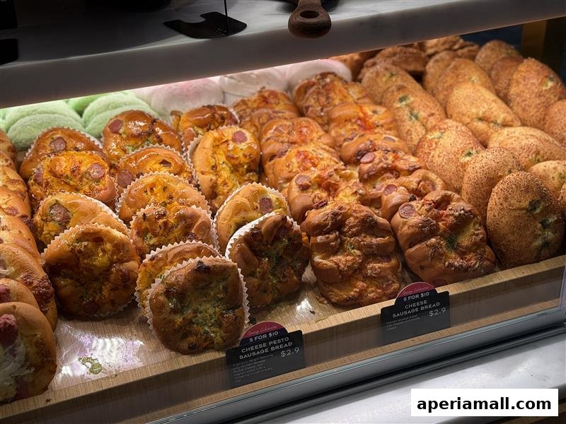 A display of freshly baked savory breads and pastries, including sausage breads.