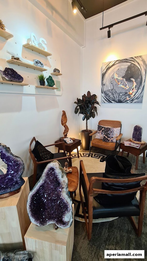 Interior of a shop featuring large amethyst geodes, seating, and artwork.