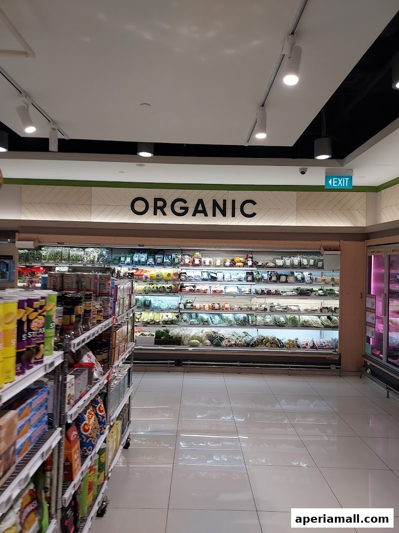 A wide shot of the organic produce section in a supermarket with shelves stocked with fresh vegetables.