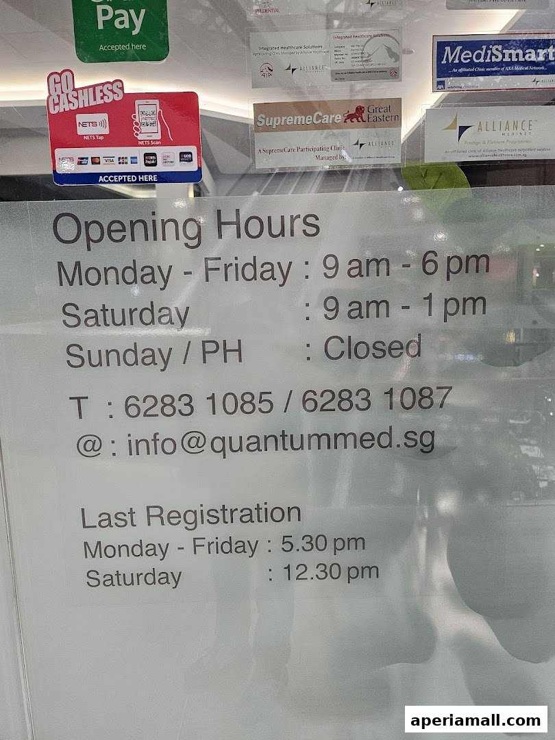 A sign displaying opening hours, contact information, and accepted payment methods for Quantum Medical Imaging.